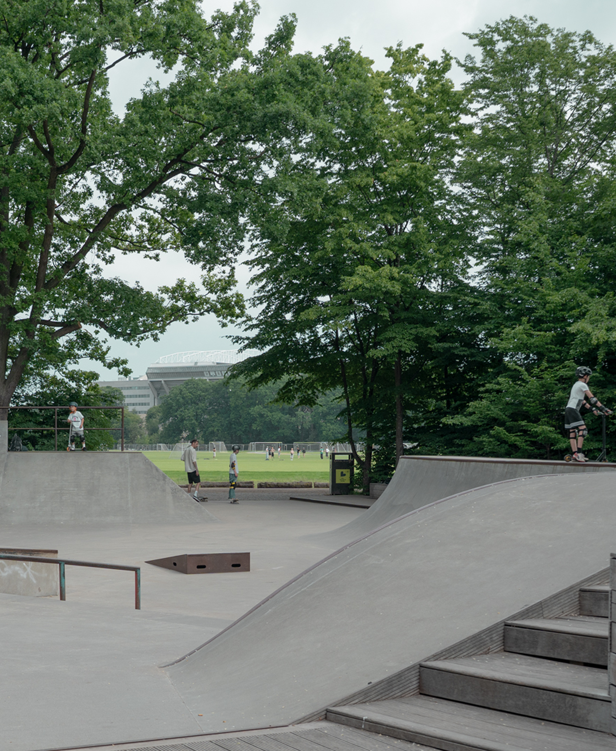 Skate park with ramps and a grassy field in the background