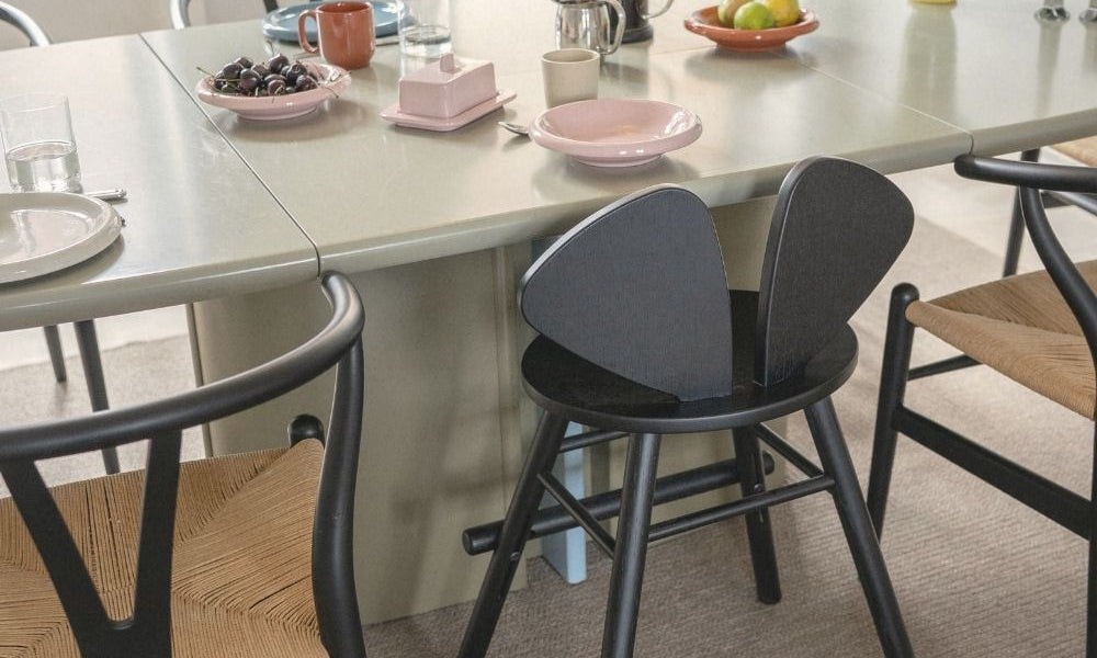Dining table with chairs and various items on a light-colored floor.