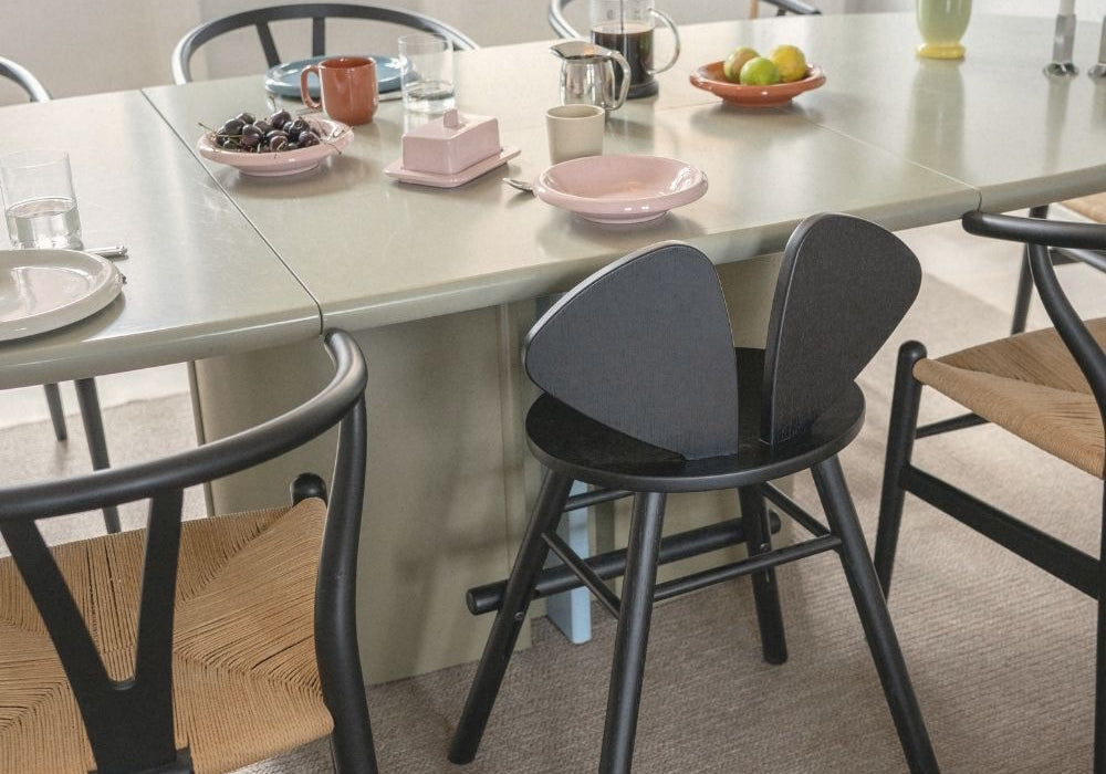 Dining table with chairs and various items on a light-colored floor.