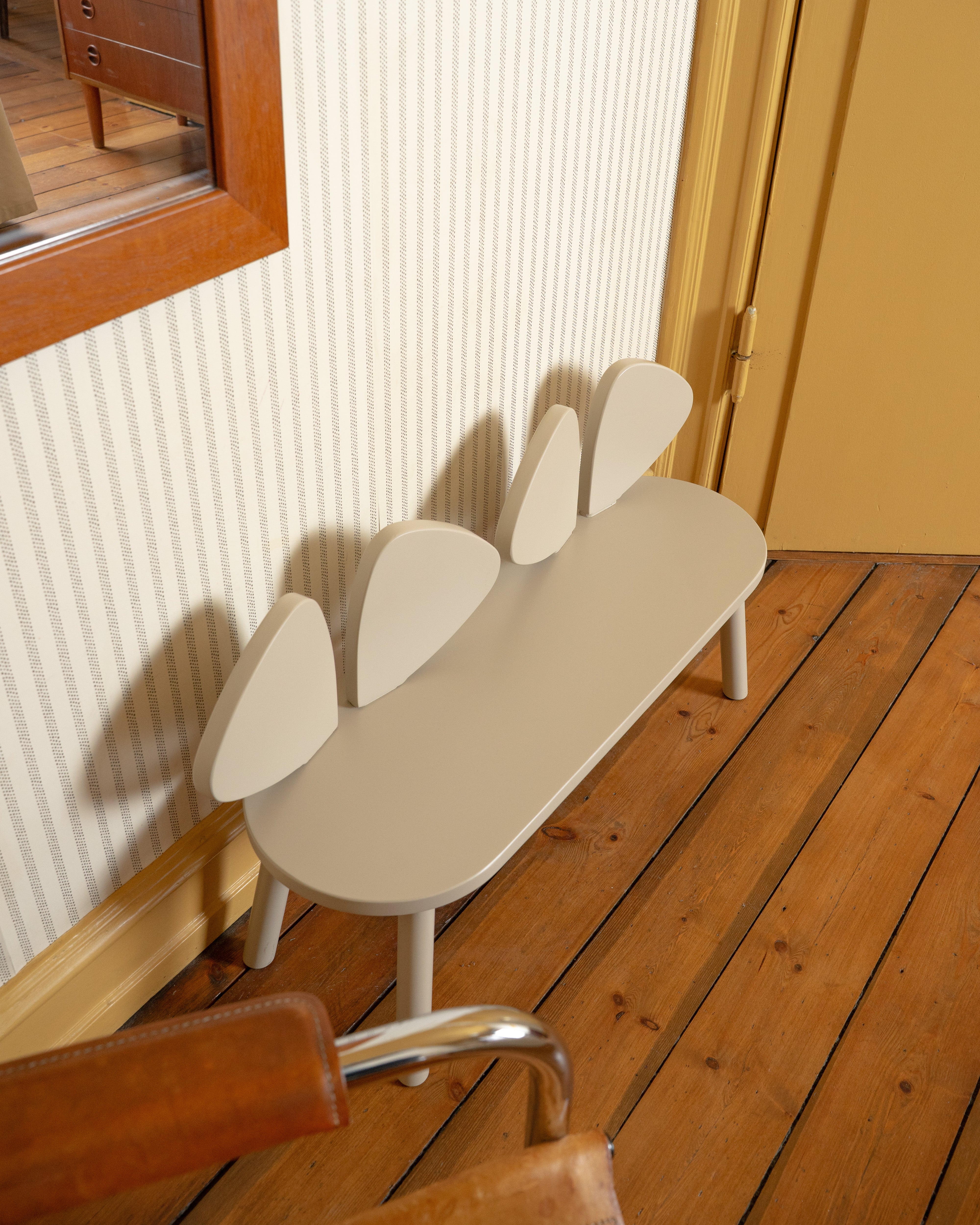 Modern bench with a unique design on a wooden floor.
