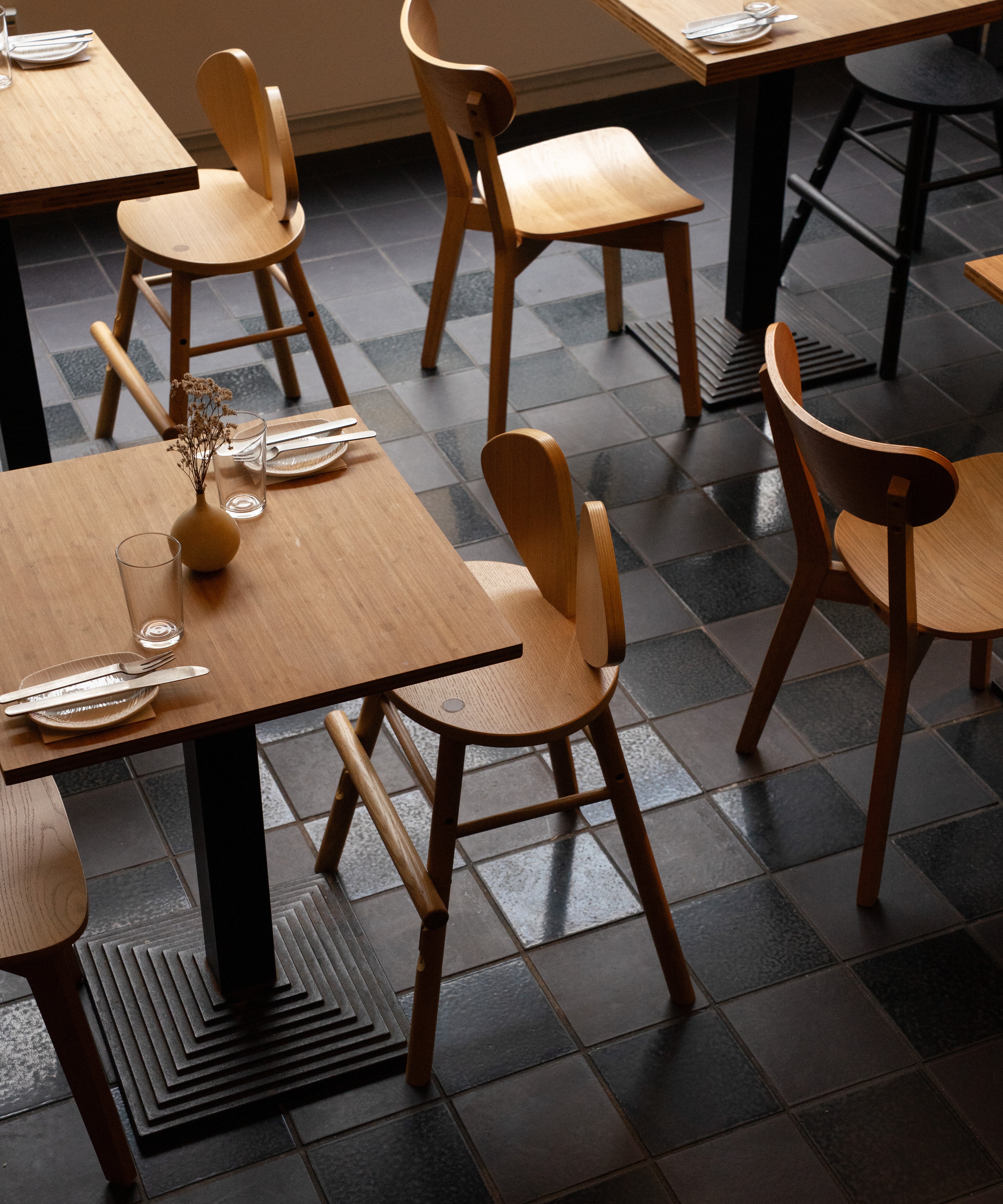 Dining area with wooden tables and chairs on a tiled floor
