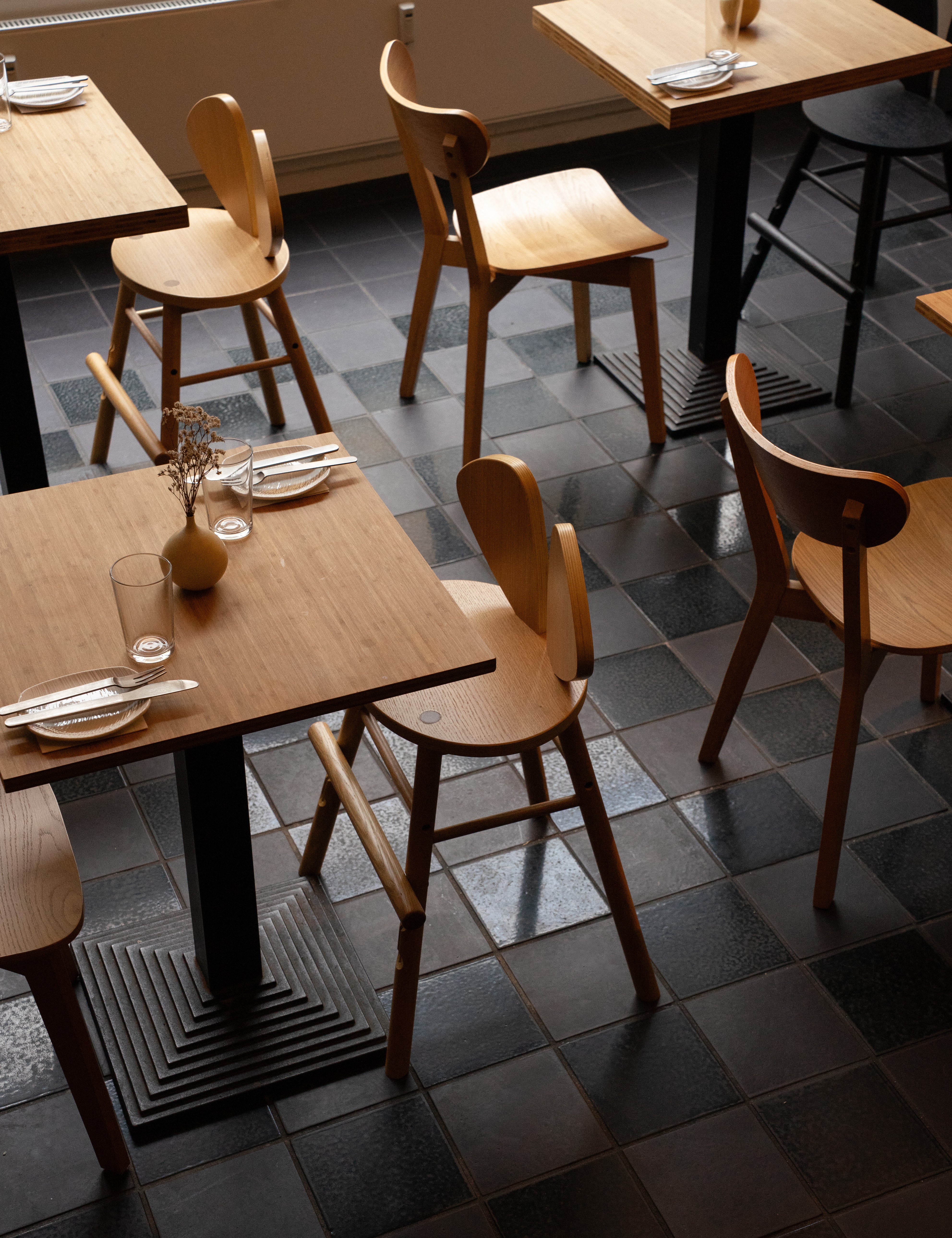 Dining area with wooden tables and chairs on a tiled floor