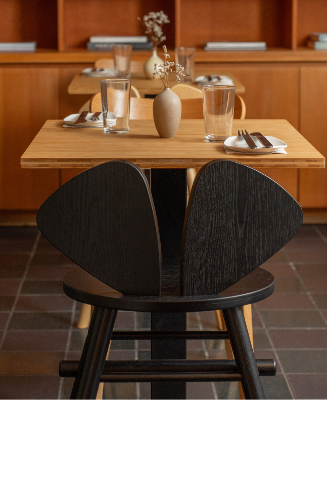 a restaurant interior with tables, chairs, and bookshelves.