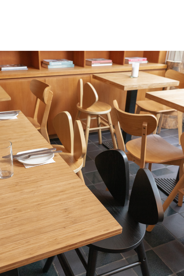 A restaurant interior with wooden tables and chairs.