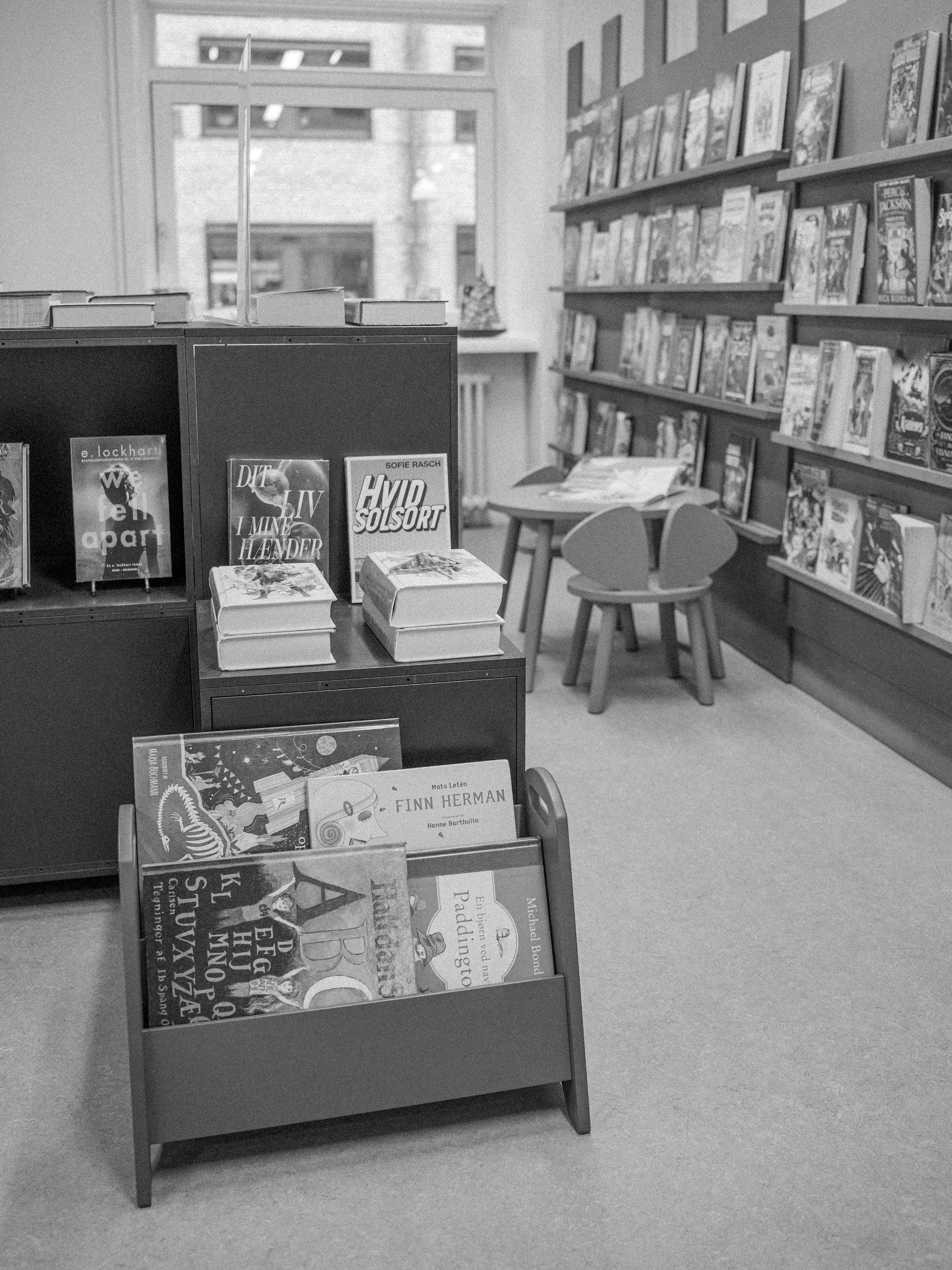 Bookstore interior with bookshelves and a display rack filled with books.