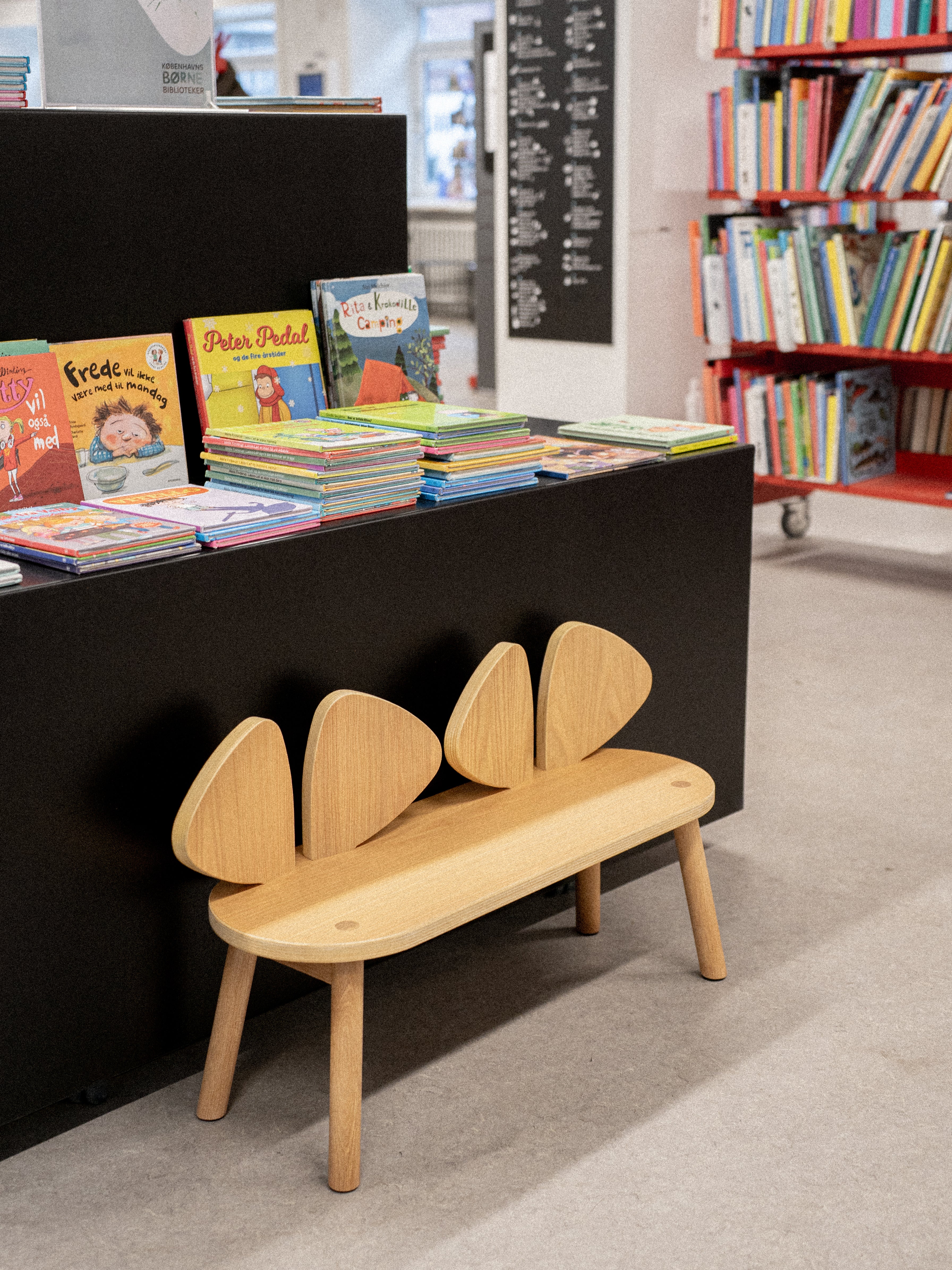 Wooden bench with animal ears in a bookstore setting