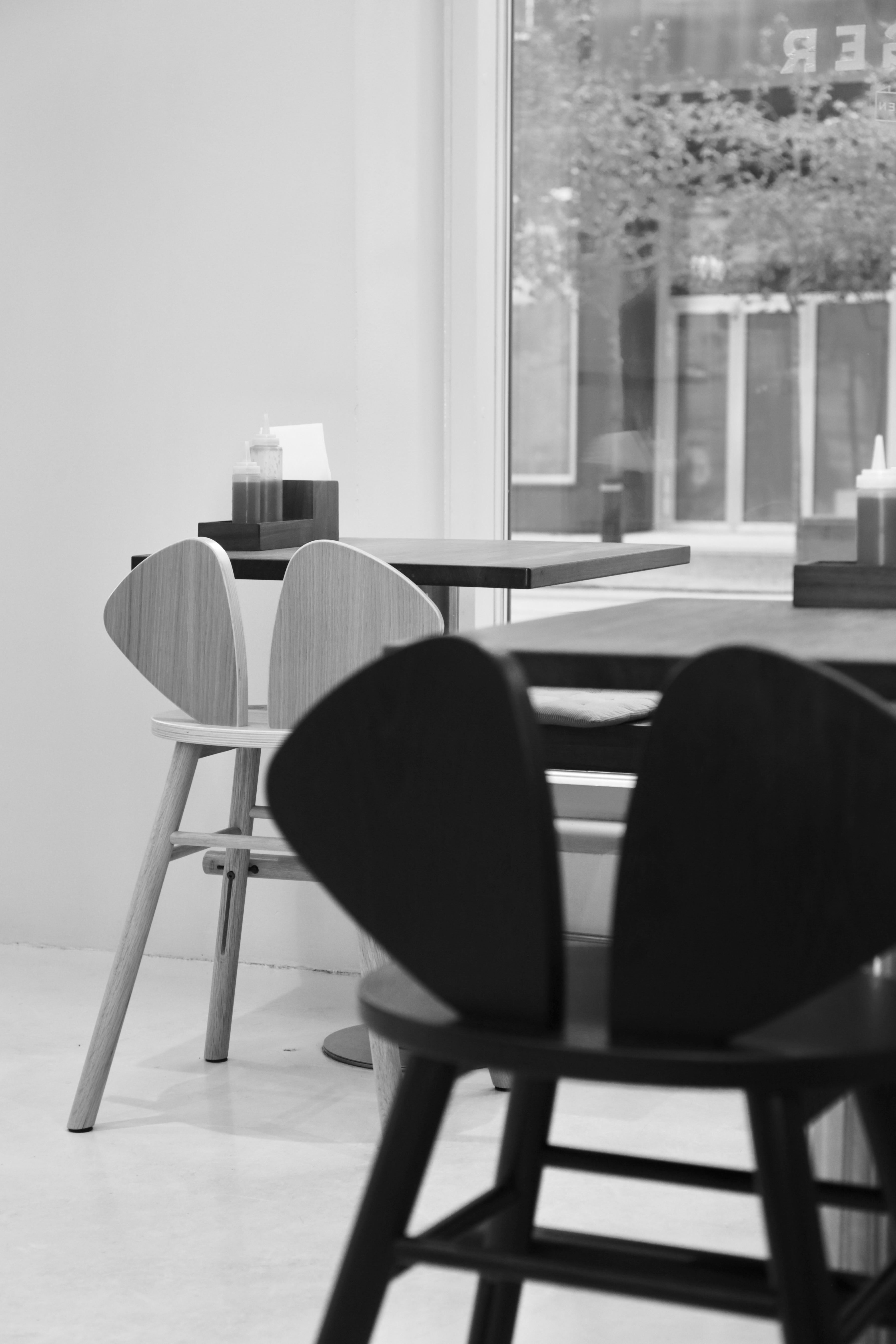 Dining area with black and gray chairs and tables in a modern interior.