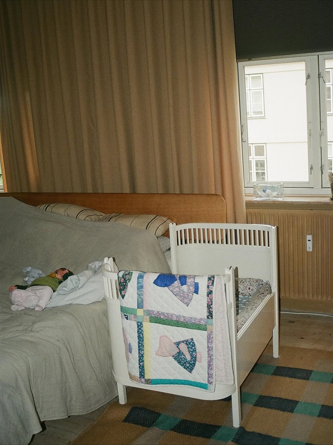 Bedroom with a bed and crib next to a window