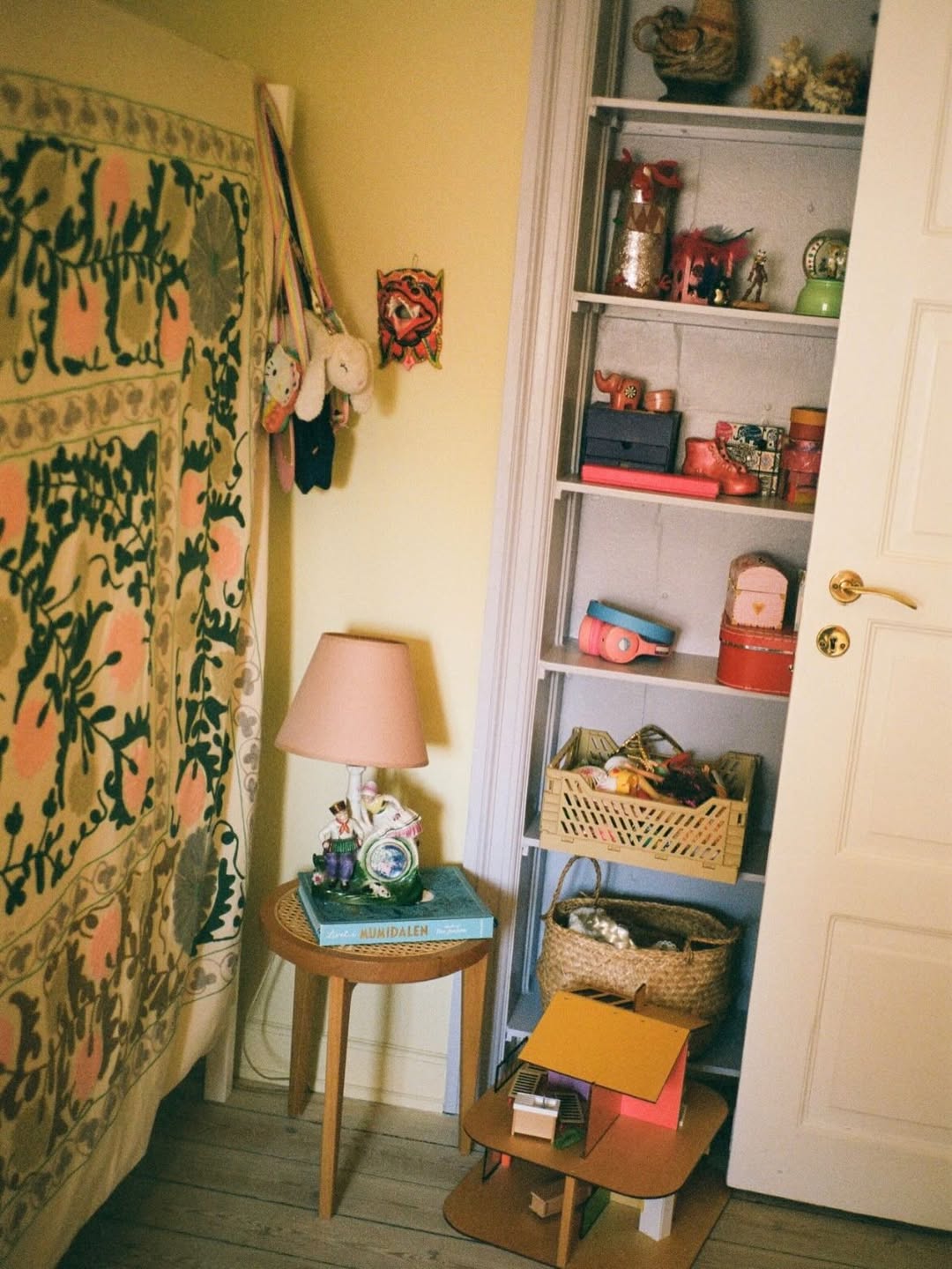 Room interior with a shelf, table, and decorative items.