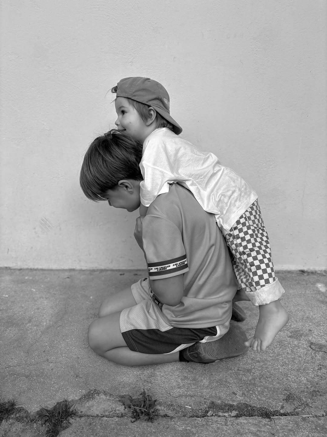 Two children playing on a concrete surface with a plain background