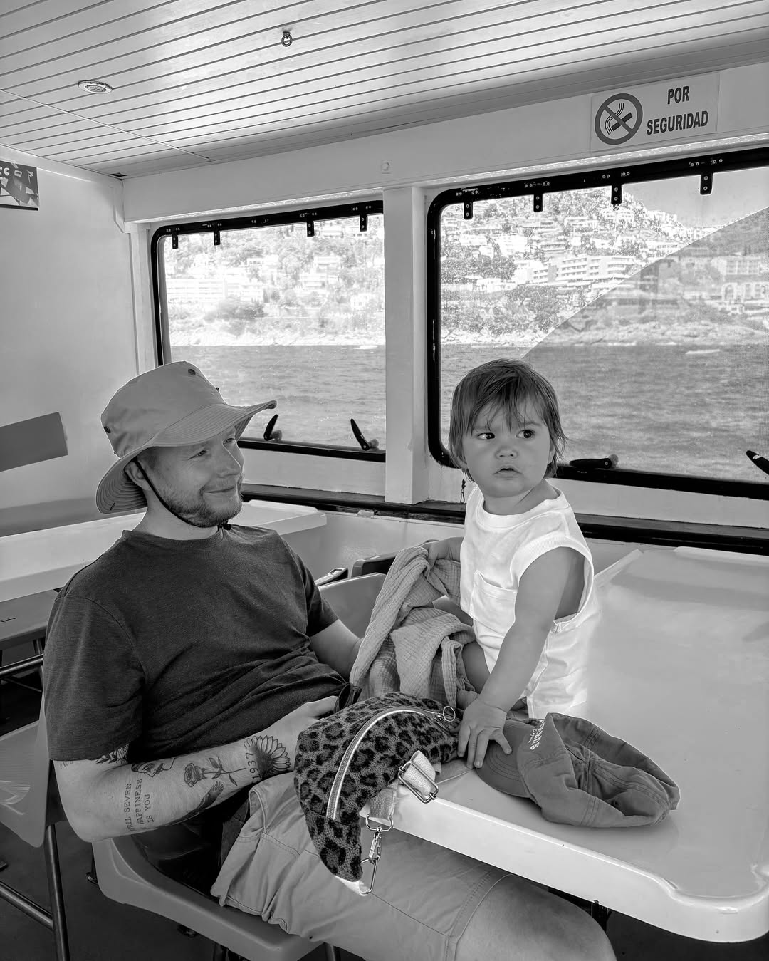 Man and child sitting inside a vehicle with scenic views outside