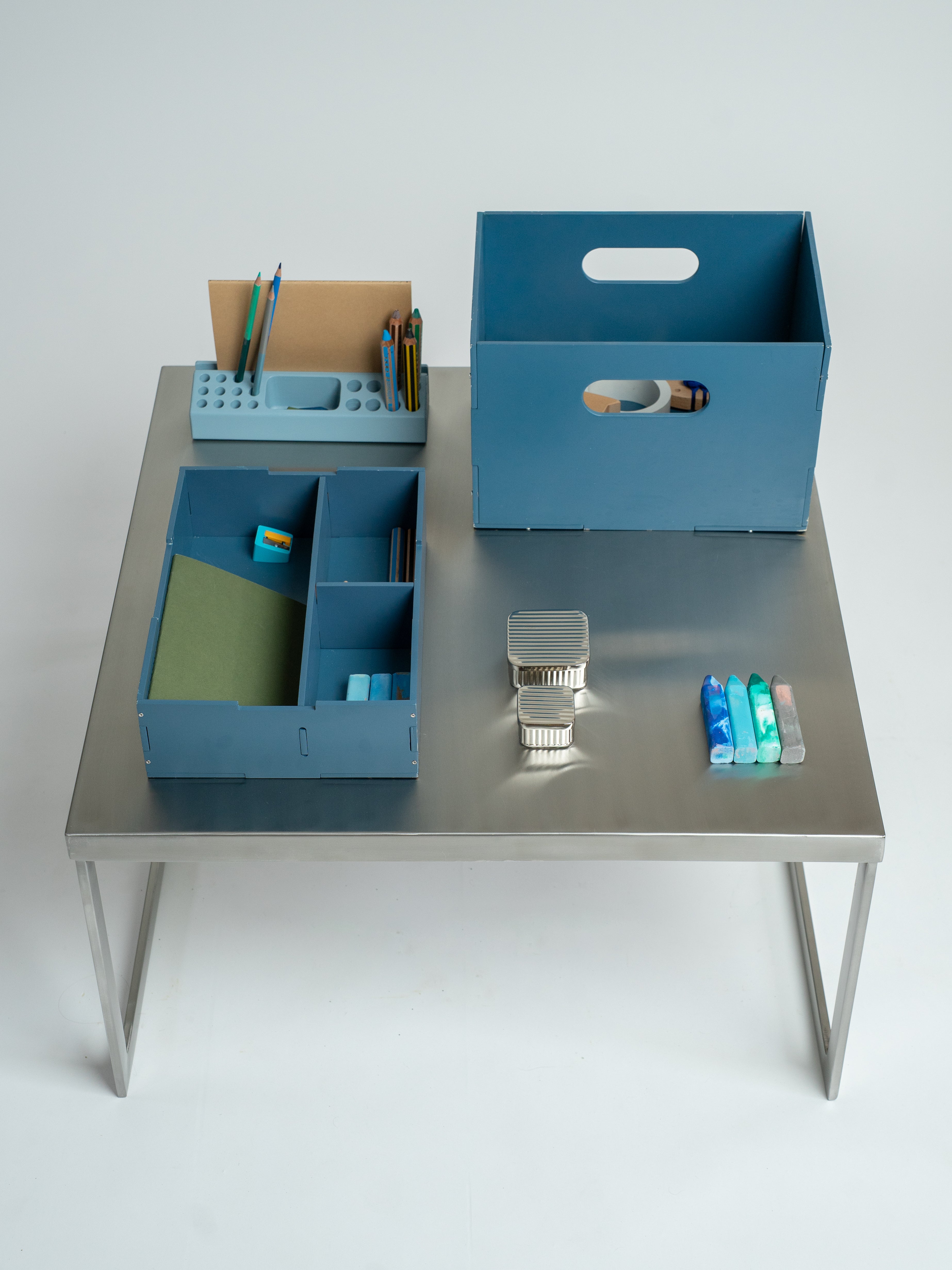 Desk with blue storage boxes and office supplies on a white background