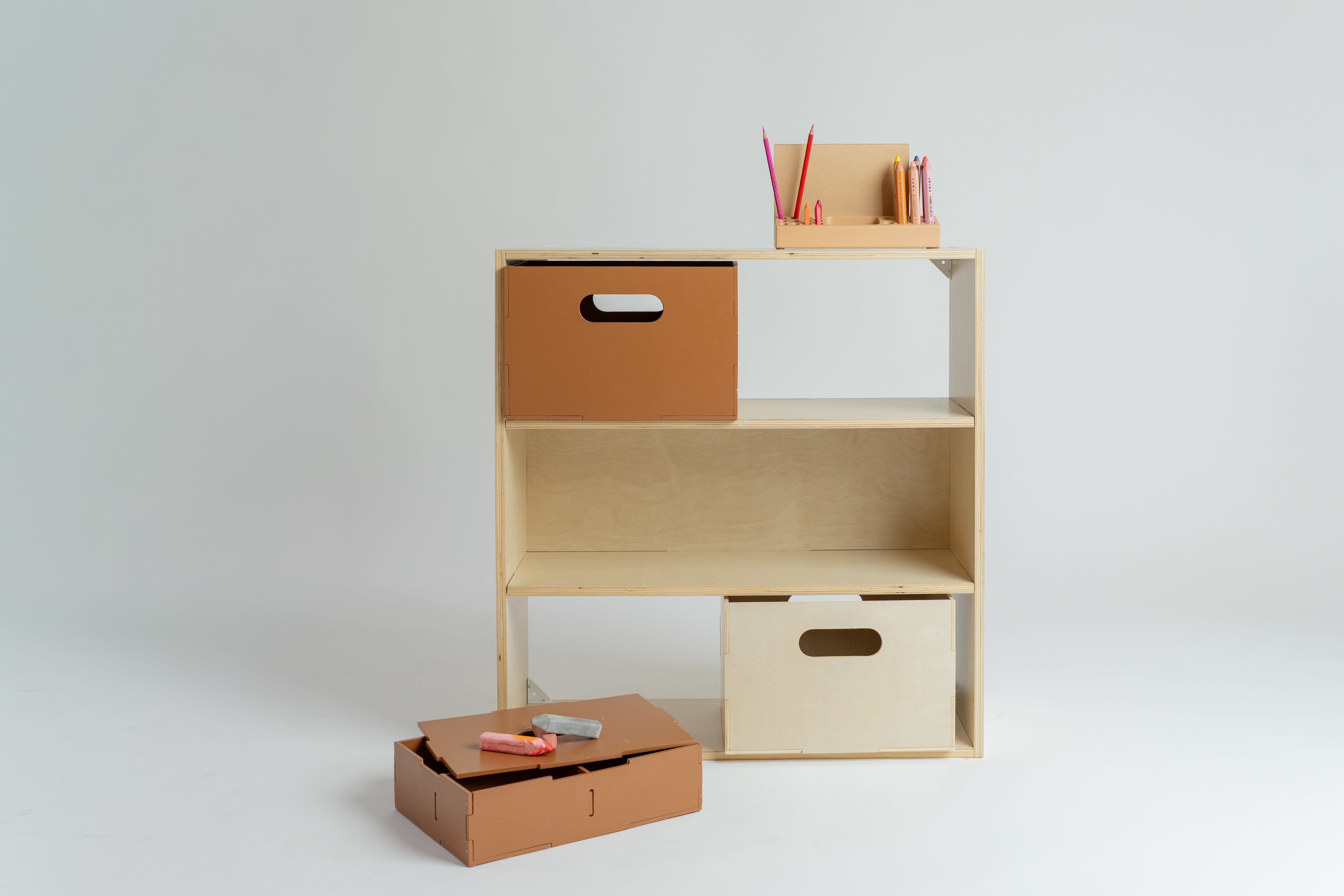 Wooden shelf with storage boxes and stationery on a white background