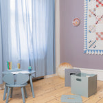 Children's room with light blue furniture, wooden floor, and decorative elements.