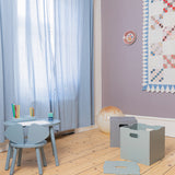 Children's room with light blue furniture, wooden floor, and decorative elements.
