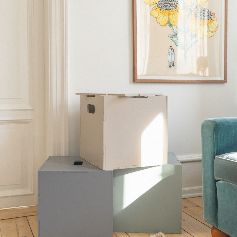 Modern glass coffee table with a white cube in a living room setting.