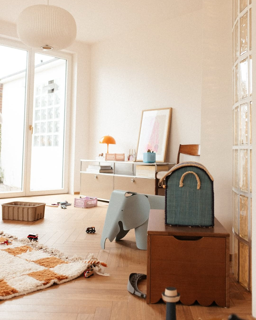 Children's room with wooden floor, toys, and furniture.