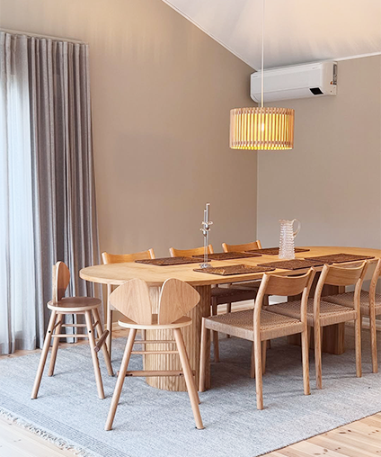 Dining room with wooden table and chairs on a light blue rug.