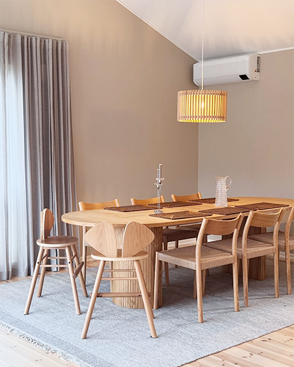 Dining room with wooden table and chairs on a light blue rug.