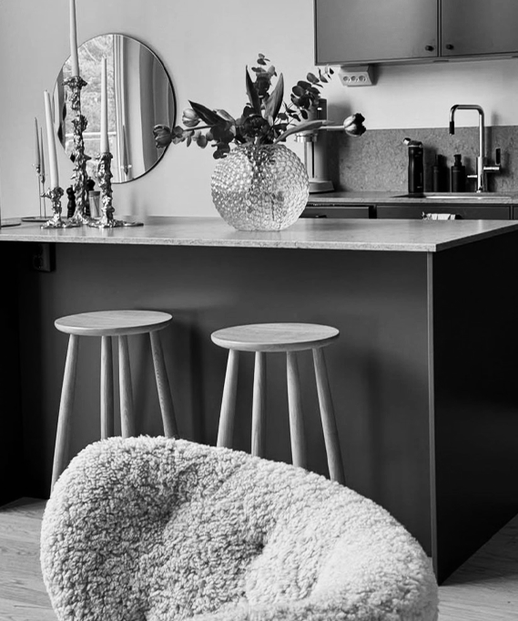 Modern kitchen with bar stools and a textured chair.