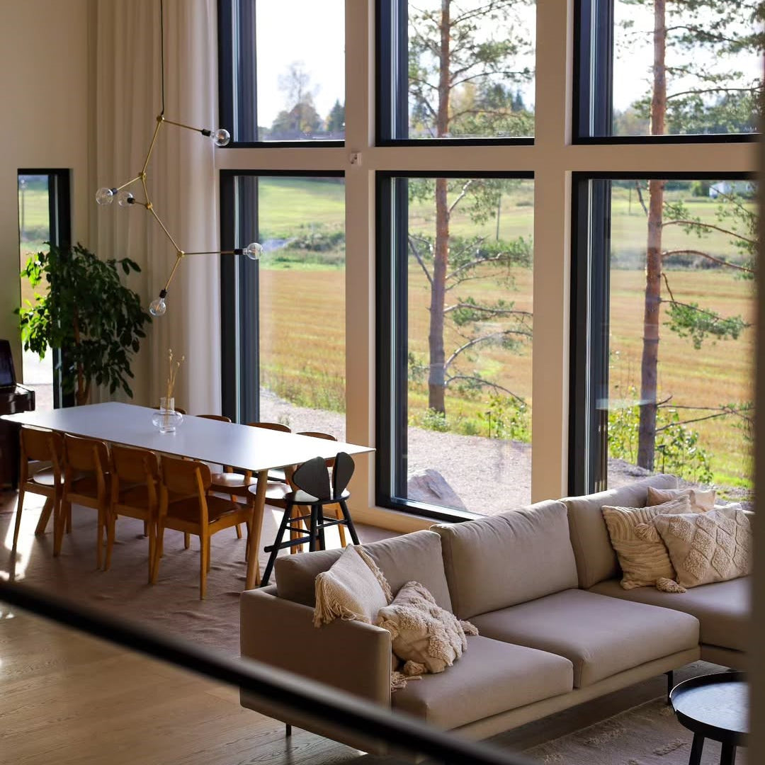 Modern living room with a large window view of trees and fields