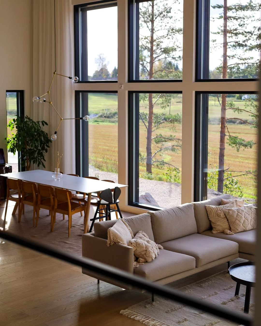 Modern living room with a large window view of trees and fields