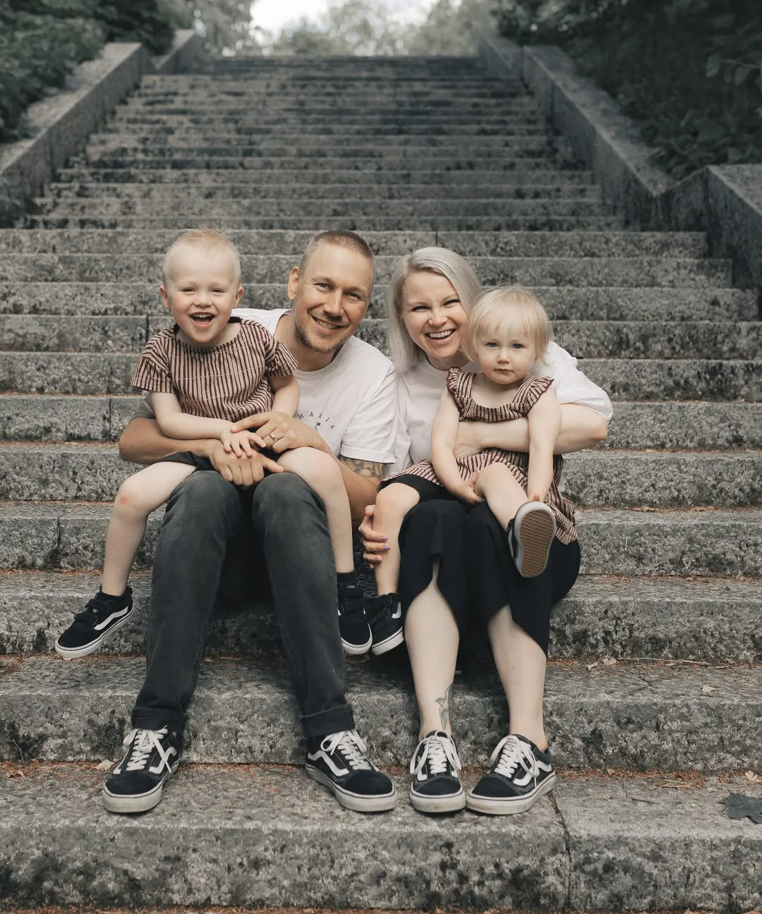 Family of four sitting on stone steps outdoors