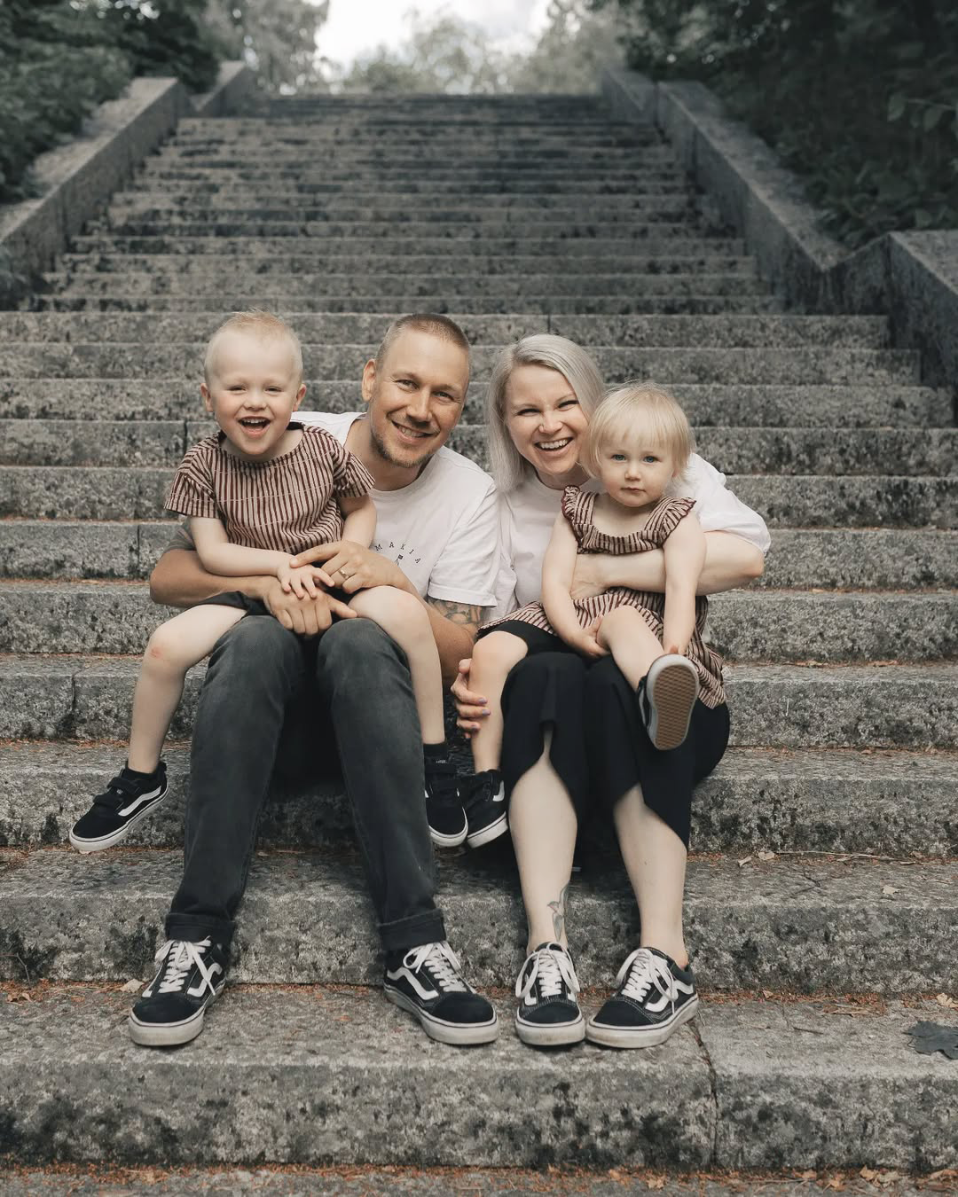 Family of four sitting on stone steps outdoors