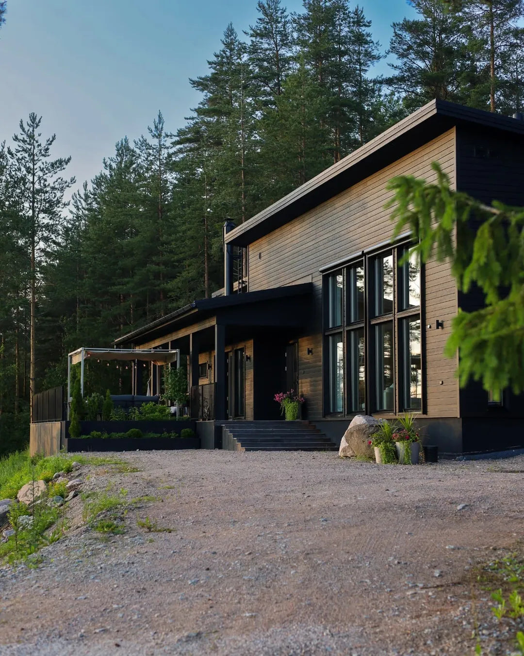 Modern house with wooden exterior and large windows in a forest setting