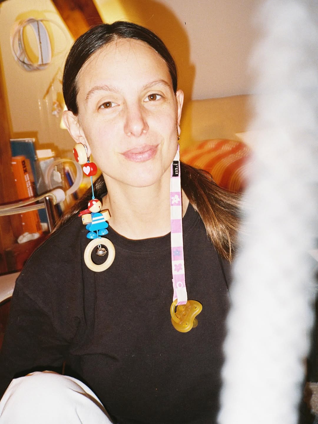 Person wearing colorful necklaces in a casual setting