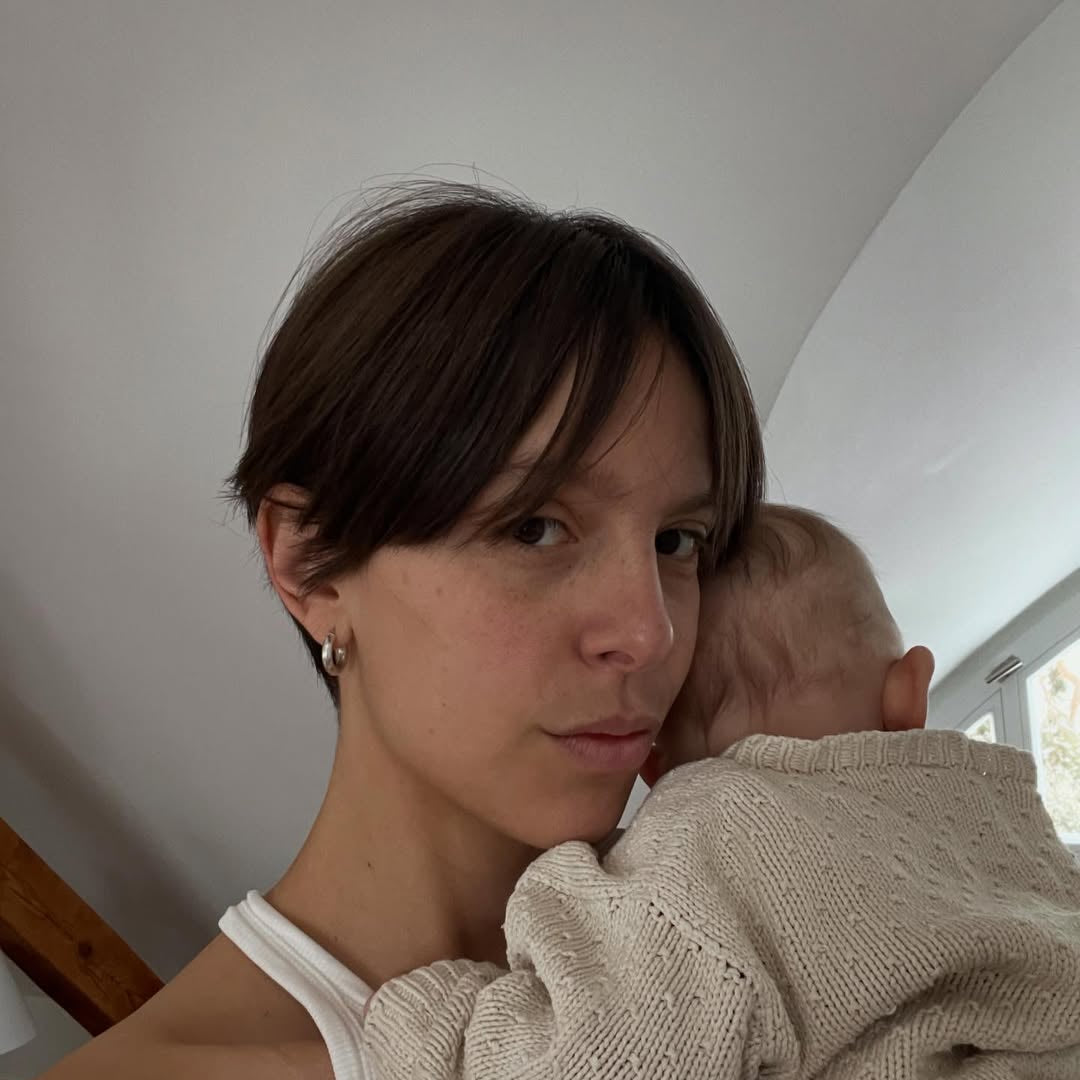 Woman holding a child close to her face indoors.