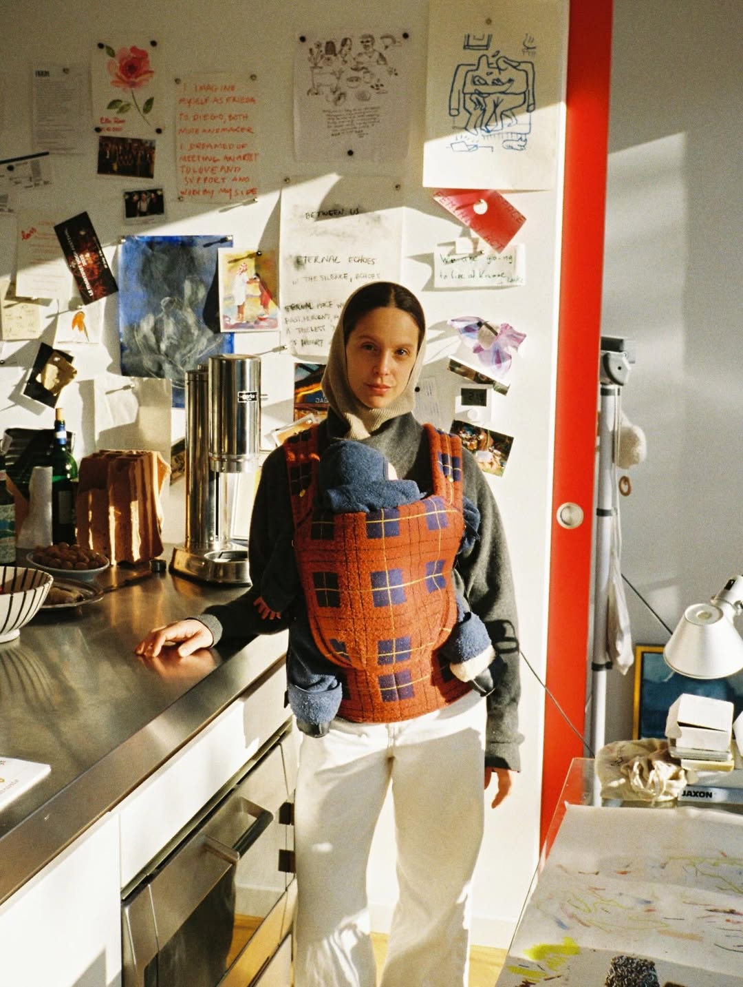 Person wearing a patterned apron in a kitchen setting with various items on the counter.