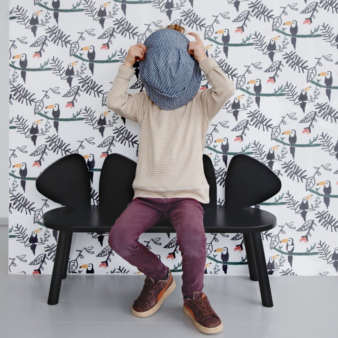 A child sitting on Nofred Black Mouse Bench