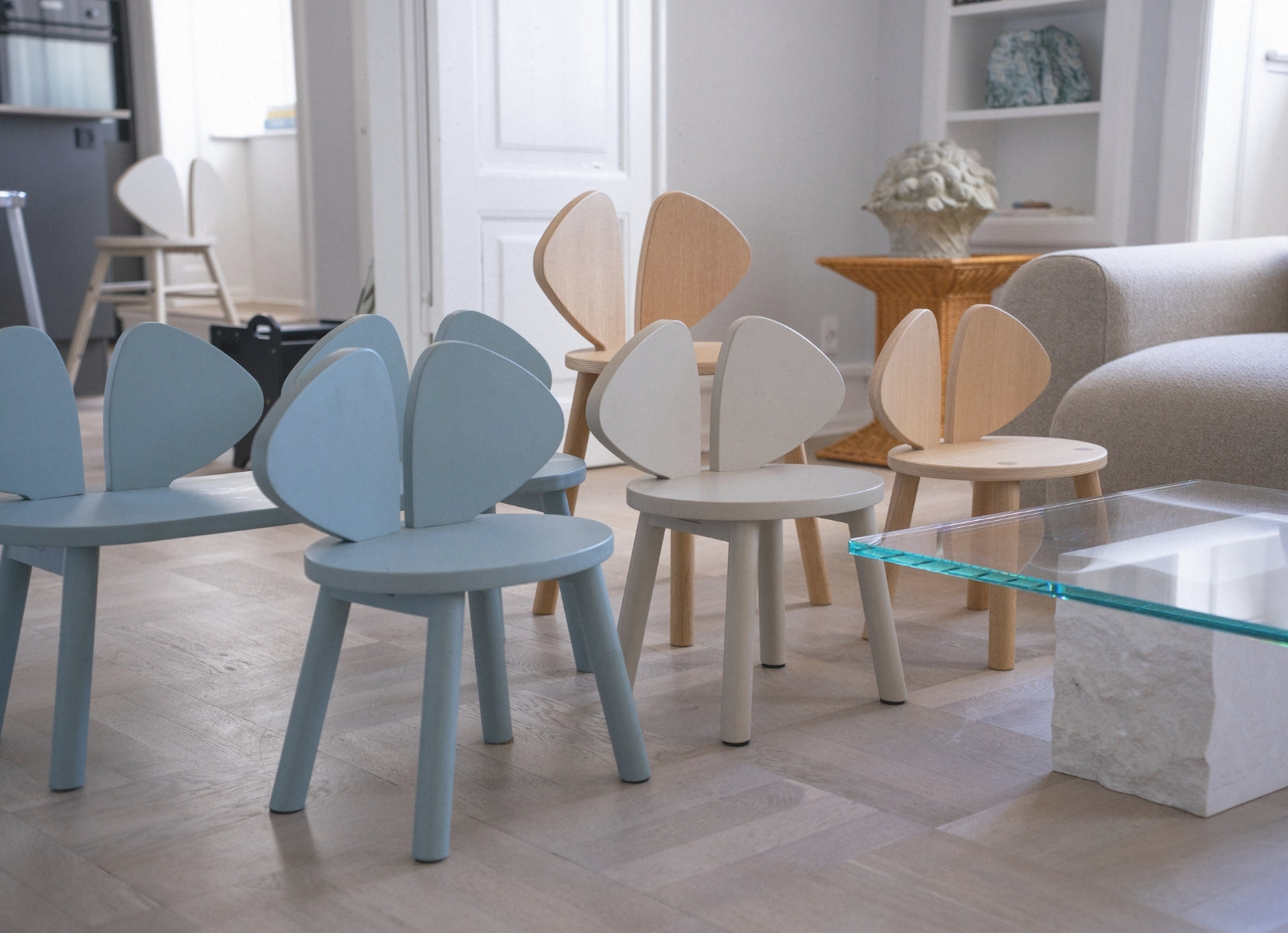 Modern furniture set with unique chairs and a glass coffee table in a living room.