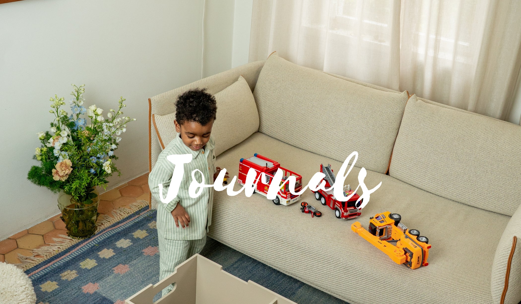 Child playing with toys on a couch in a living room, with 'Journals' text overlay.