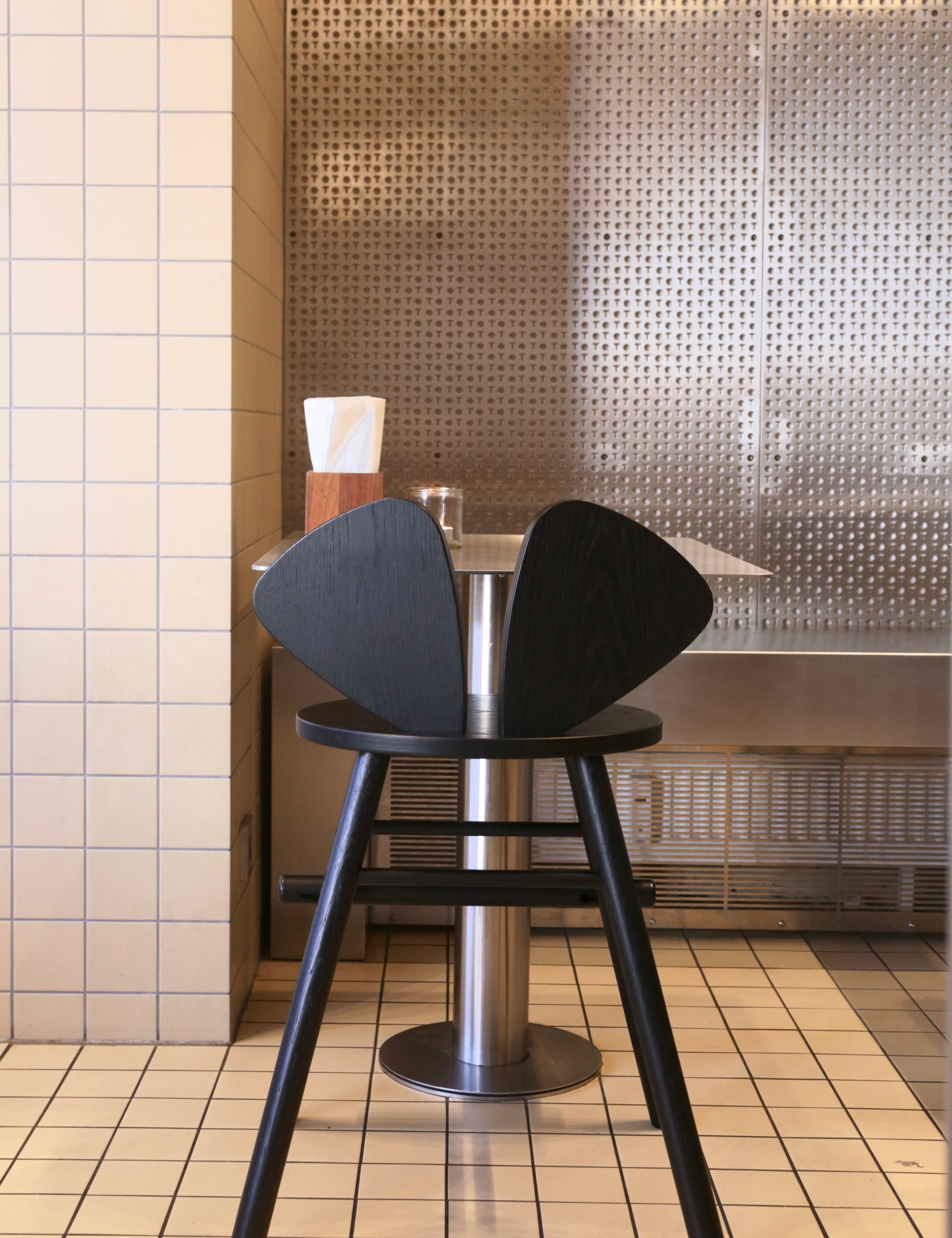 Black chair with a metallic base in a tiled room