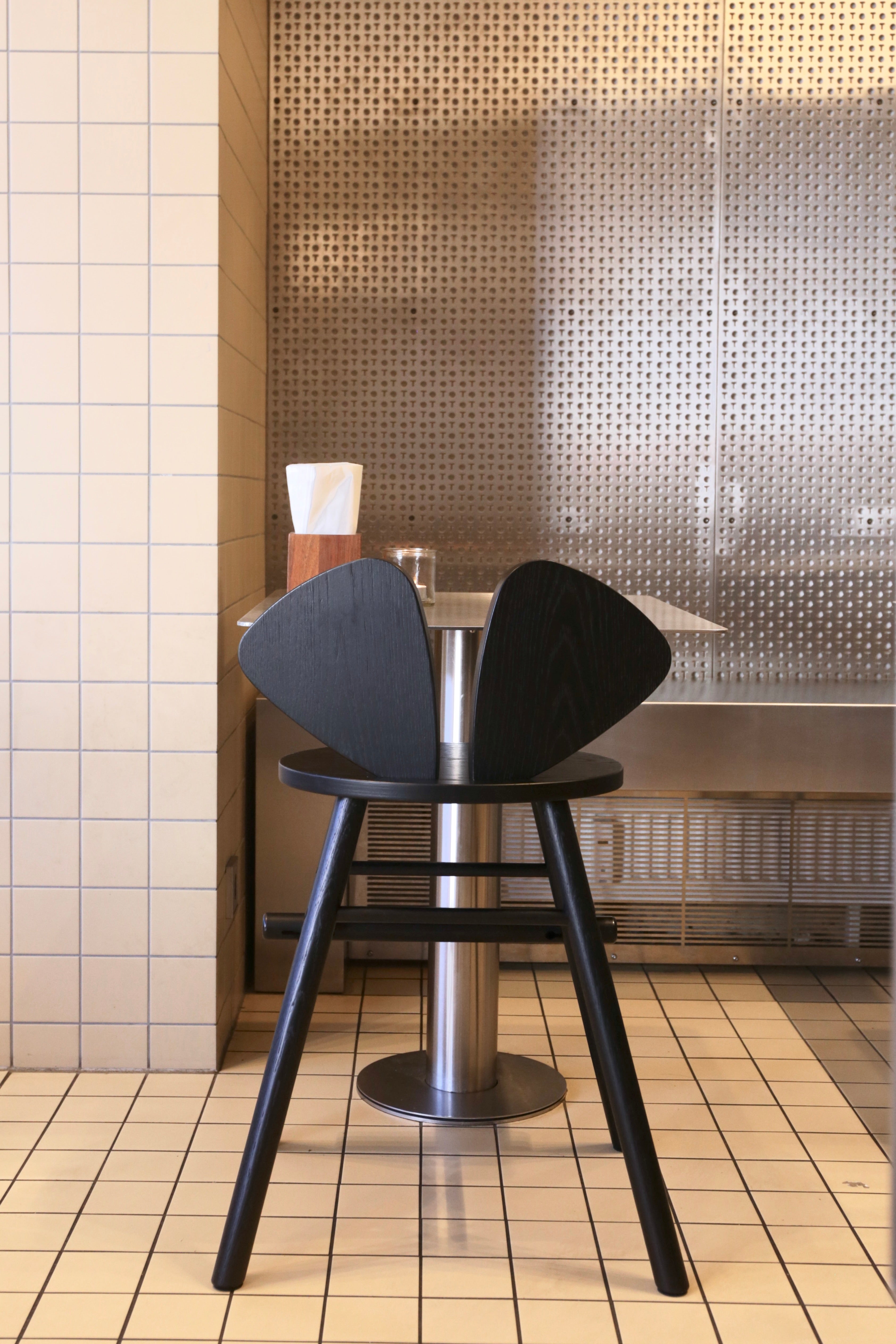 Black chair with a metallic base in a tiled room