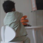 Child sitting on Mouse chair in front of mouse table