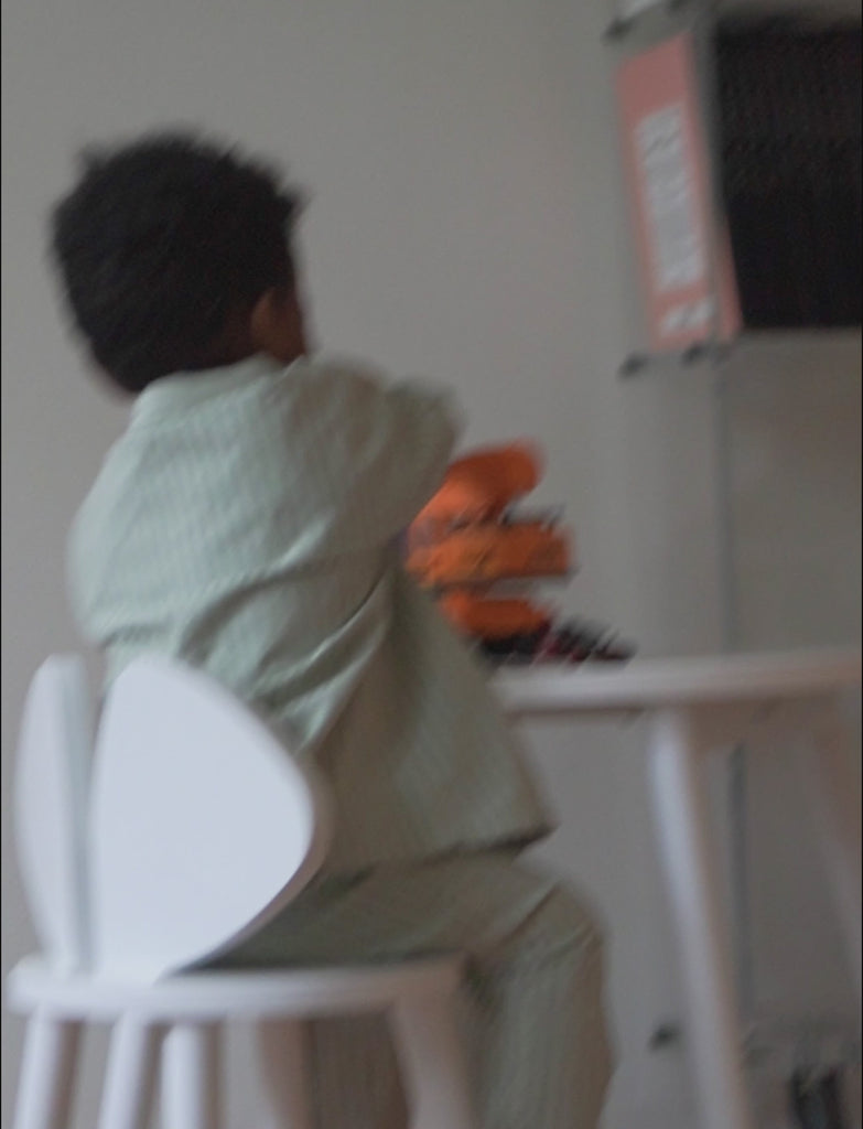 Child sitting on Mouse chair in front of mouse table