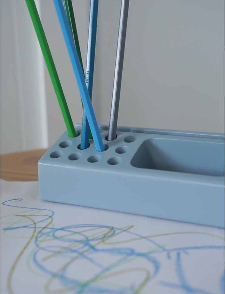 Pen holder blue with pens and a drawing on Mouse table
