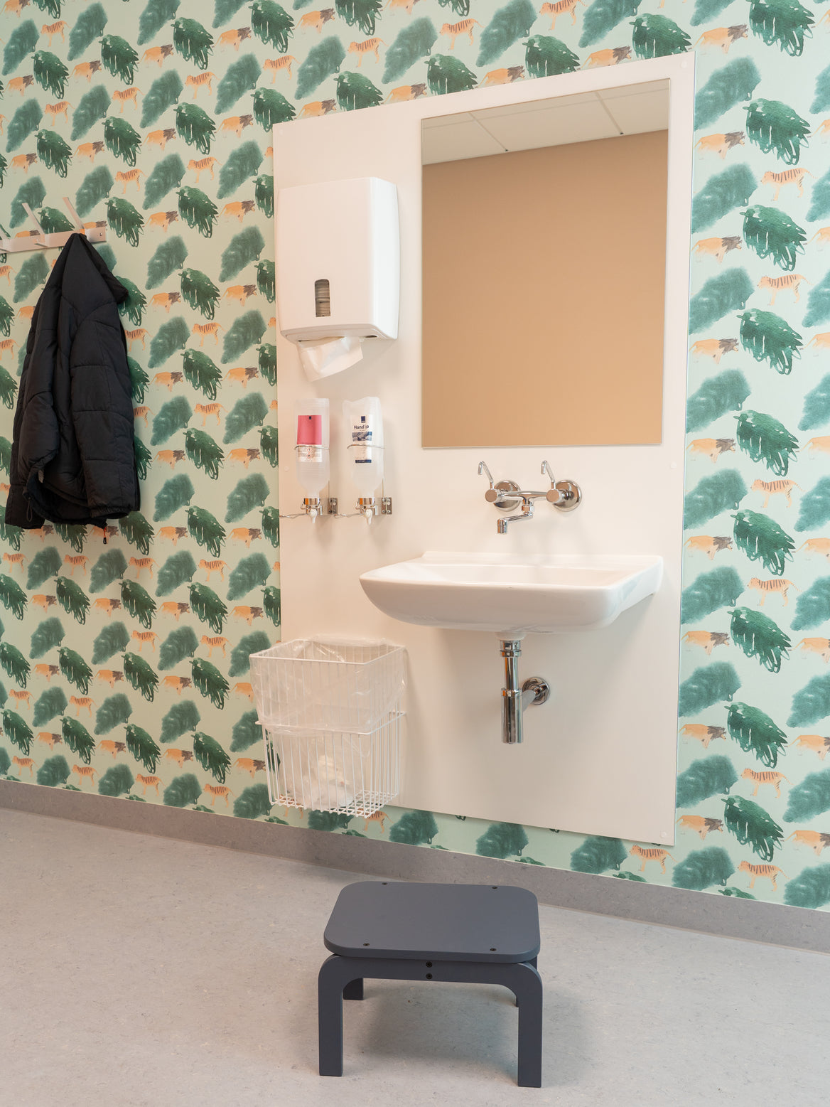 Bathroom with sink, mirror, and patterned wallpaper