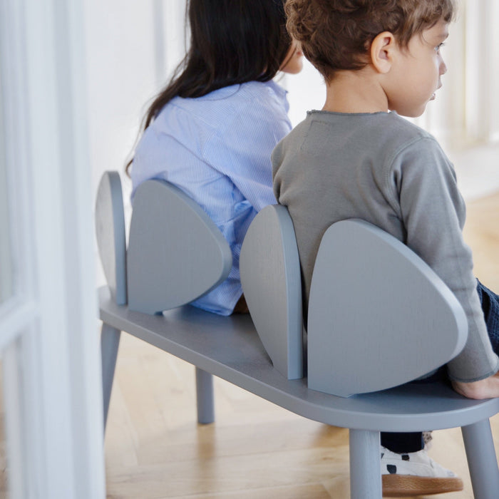 Two Kids sitting on a bench, backrest shaped as mouse ears