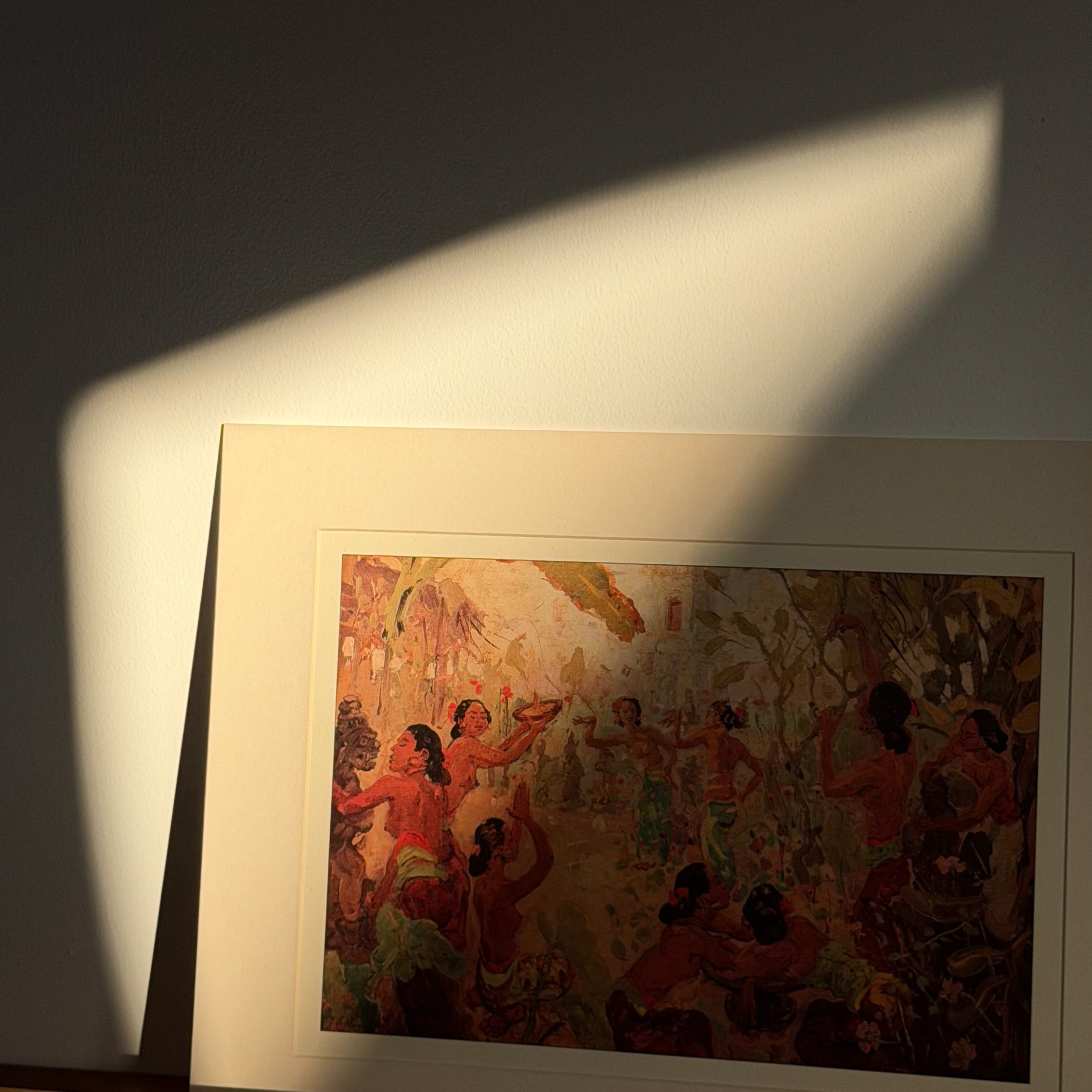 Framed artwork on a wall with a soft light casting a shadow